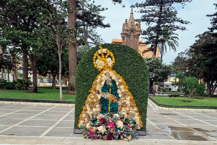 Figura de Santa María de África con flores naturales disecadas